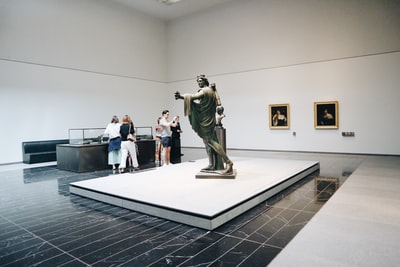 The man standing next to the statue
